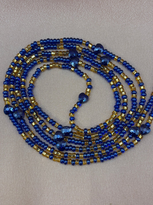 Her Majesty African waist beads featuring strands of deep royal blue and metallic gold seed beads with faceted dark blue heart-shaped accents.