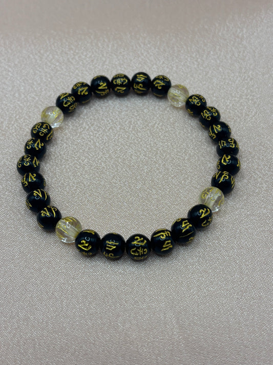 Nirvana handcrafted elastic stretch bracelet featuring black stone beads with gold mantra script and clear crystals by Beadiful Adornments.