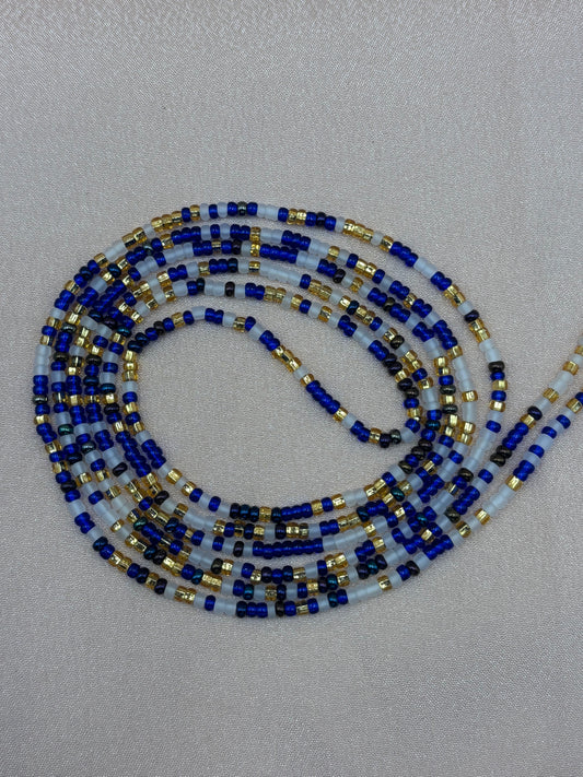 Crowned in Sapphire handcrafted waist beads featuring a regal pattern of royal sapphire blue, matte white, and shimmering gold glass seed beads by Beadiful Adornments.