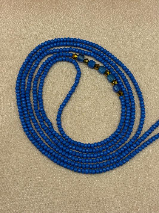 Royal Opulence blue beaded eyeglass chain with natural blue agate crystals coiled on a plain background.